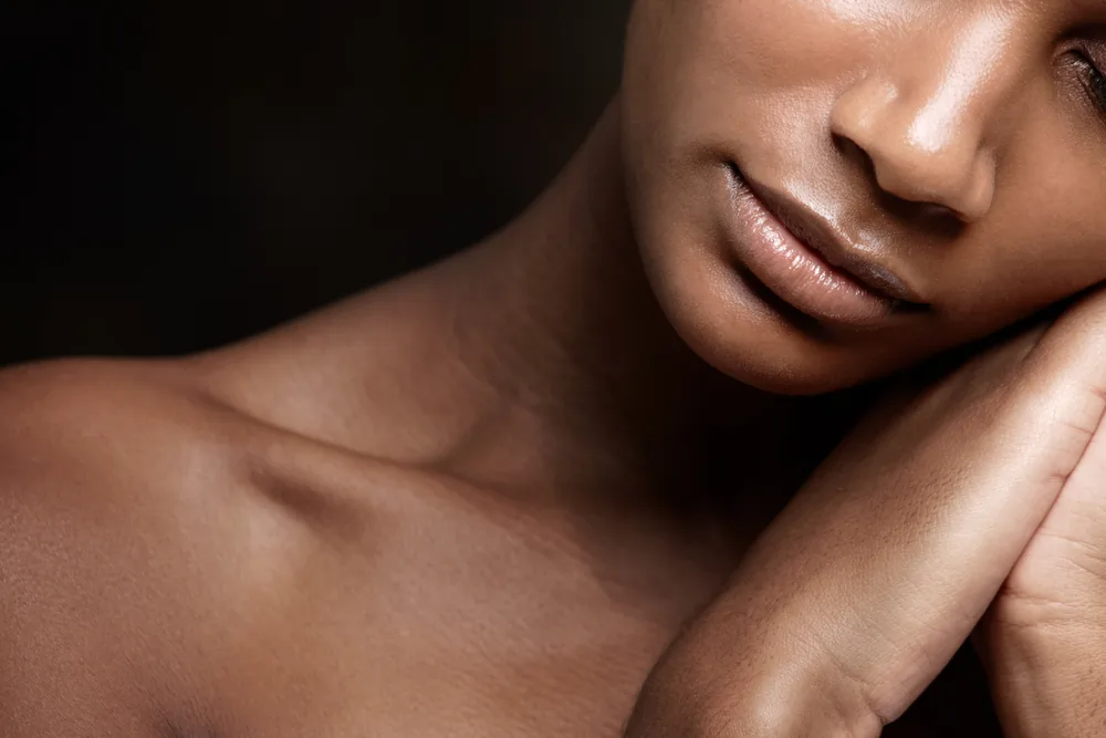 Close-up of a woman with flawless skin resting peacefully against a dark background, symbolizing the rejuvenating effects of microneedling with PRFM.
