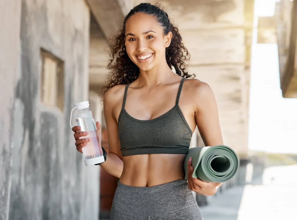 Woman holding a wellness product while wearing activewear